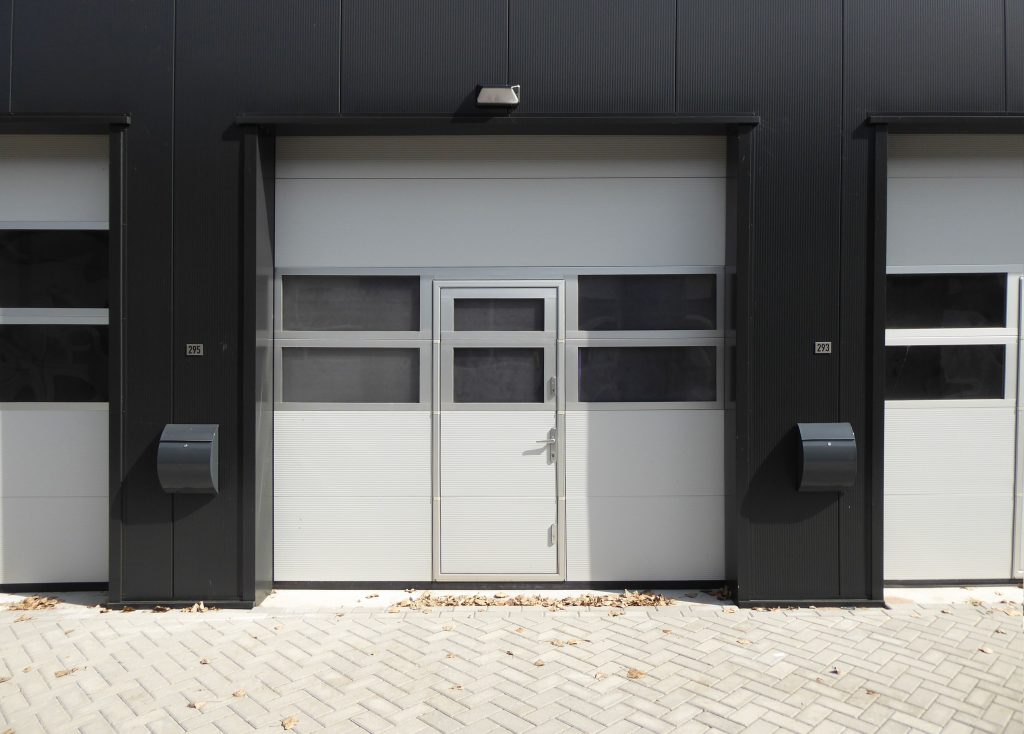 Modern industrial style garage door with entrance and glass panels
