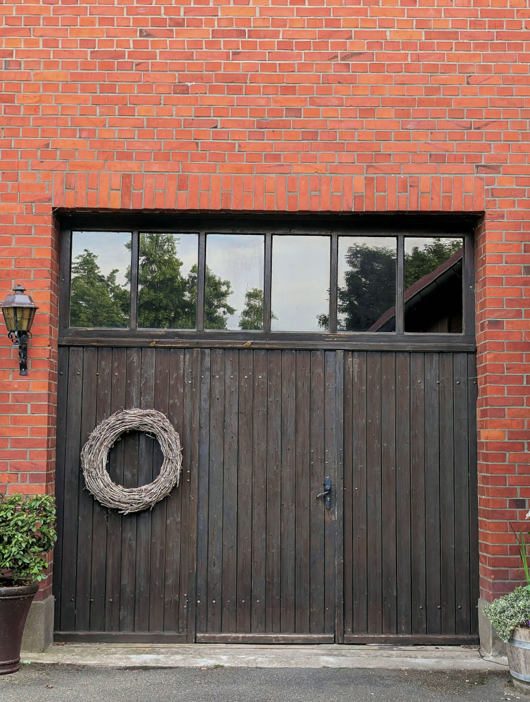 Rustic brick garage with wooden doors and a wreath